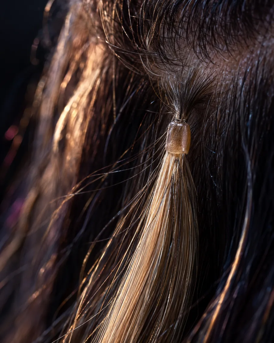 Makroaufnahme einer Keratin-Verbindung zwischen Extension und Eigenhaar, mit Abstand zur Kopfhaut